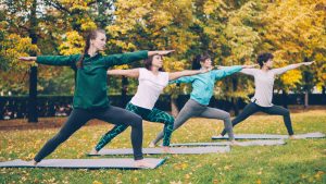 People in an outdoor group yoga class, one of the free summer fitness in Detroit options