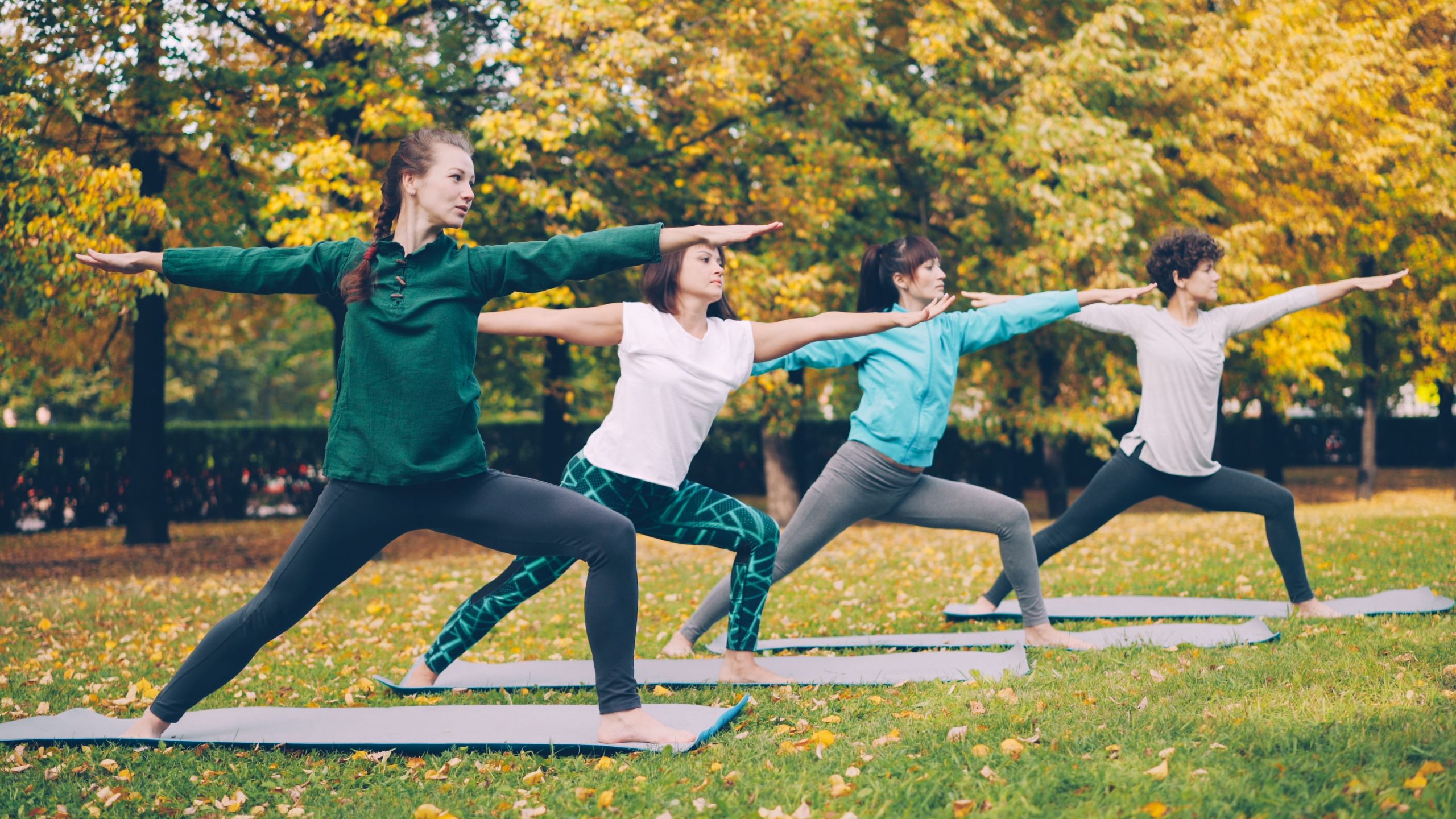People in an outdoor group yoga class, one of the free summer fitness in Detroit options